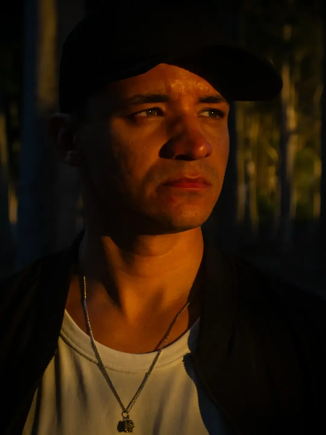 Retrato de homem com boné, rosto iluminado pela luz do fim da tarde.
