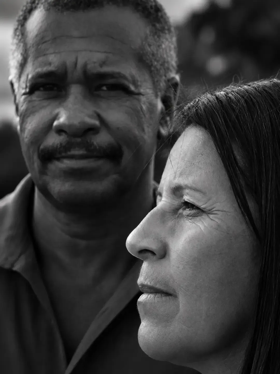 Retrato em preto e branco de um casal lado a lado, visto de perto.